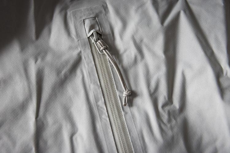 Zip et tirette des immenses poches de la veste coupe vent Odlo Essentials 2.5L Zip et tirette des immenses poches de la veste coupe vent Odlo Essentials 2.5L