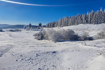 Vue sur la domerie et le village d'Aubrac depuis le bord de route