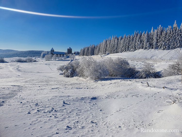 Vue sur la domerie et le village d'Aubrac depuis le bord de route